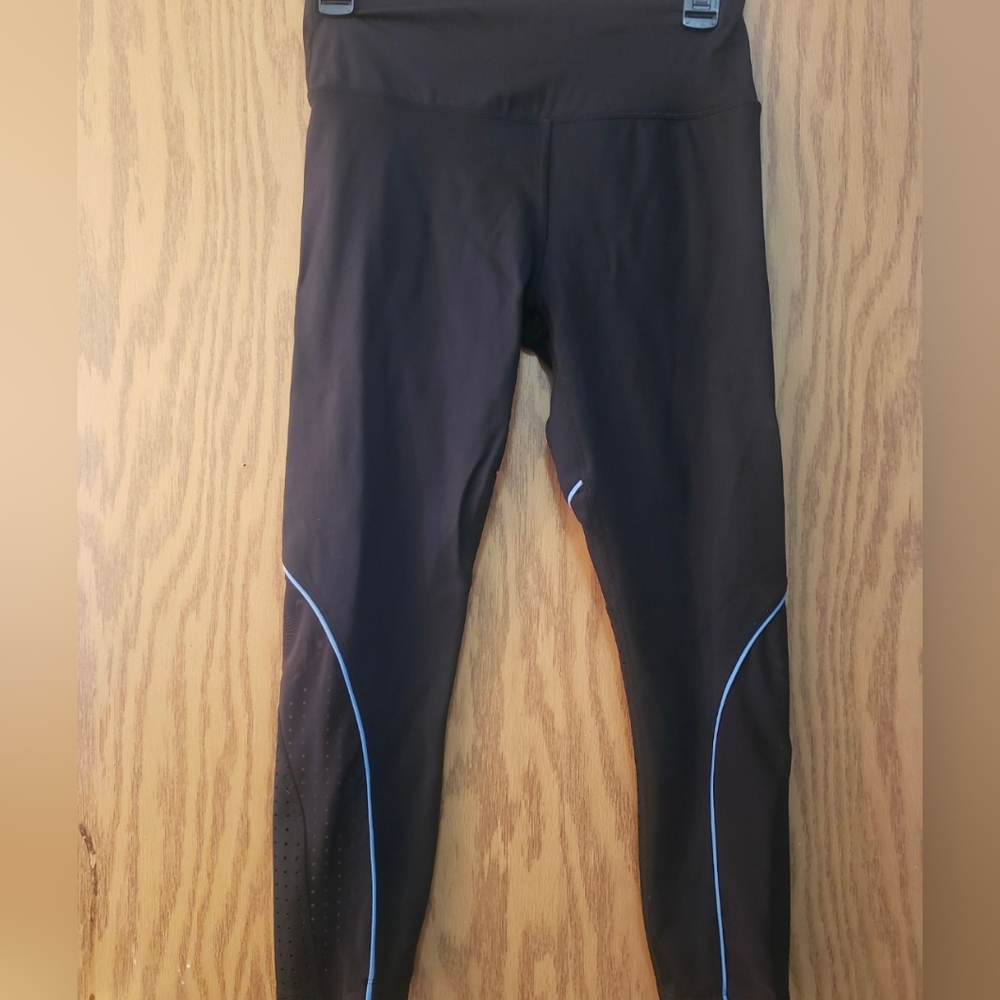 Cute ladies' black workout leggings with blue piping and air hole details